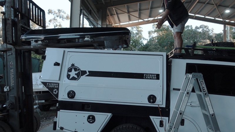 Lifting a roof top tent onto a car
